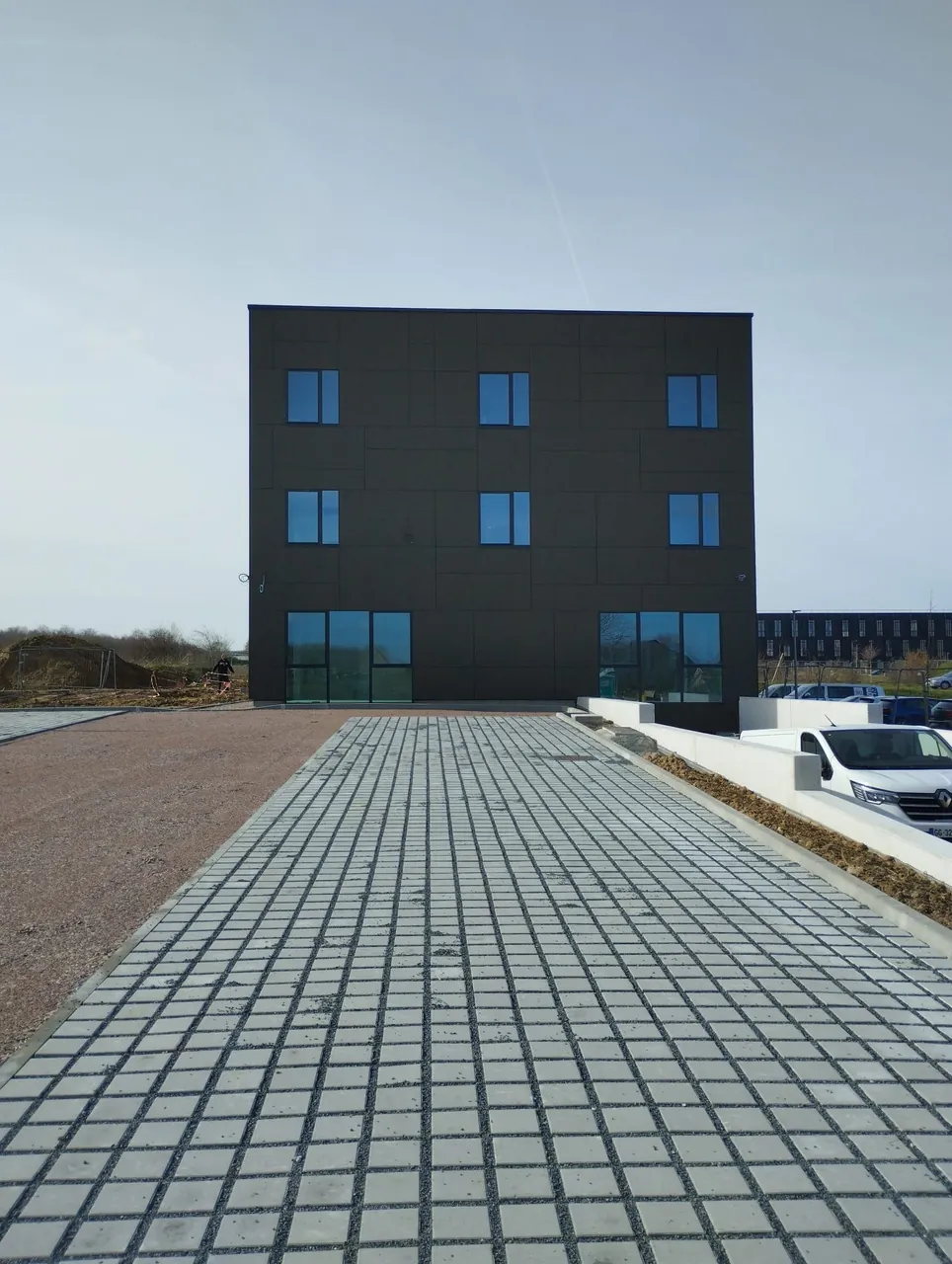 Parvis et façade d'un immeuble de bureaux à Épron entretenus régulièrement