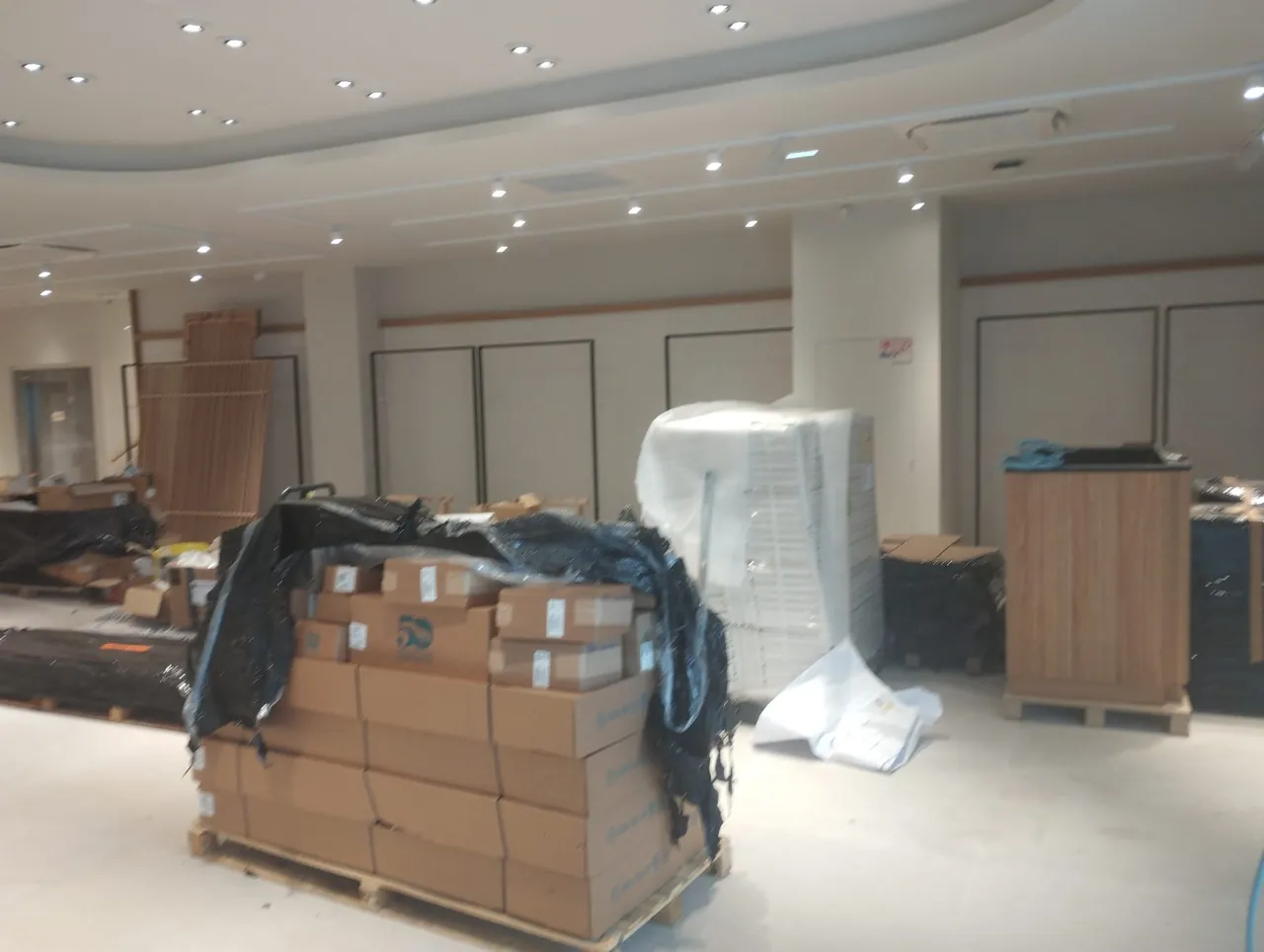 Palettes et cartons de livraison dans un magasin de prêt-à-porter à Caen avant remise en propreté